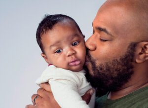 Father kisses baby on cheek