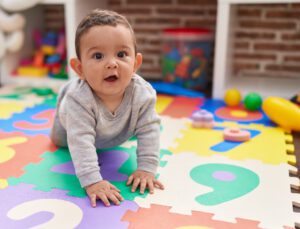 a baby boy is crawling on a playmat